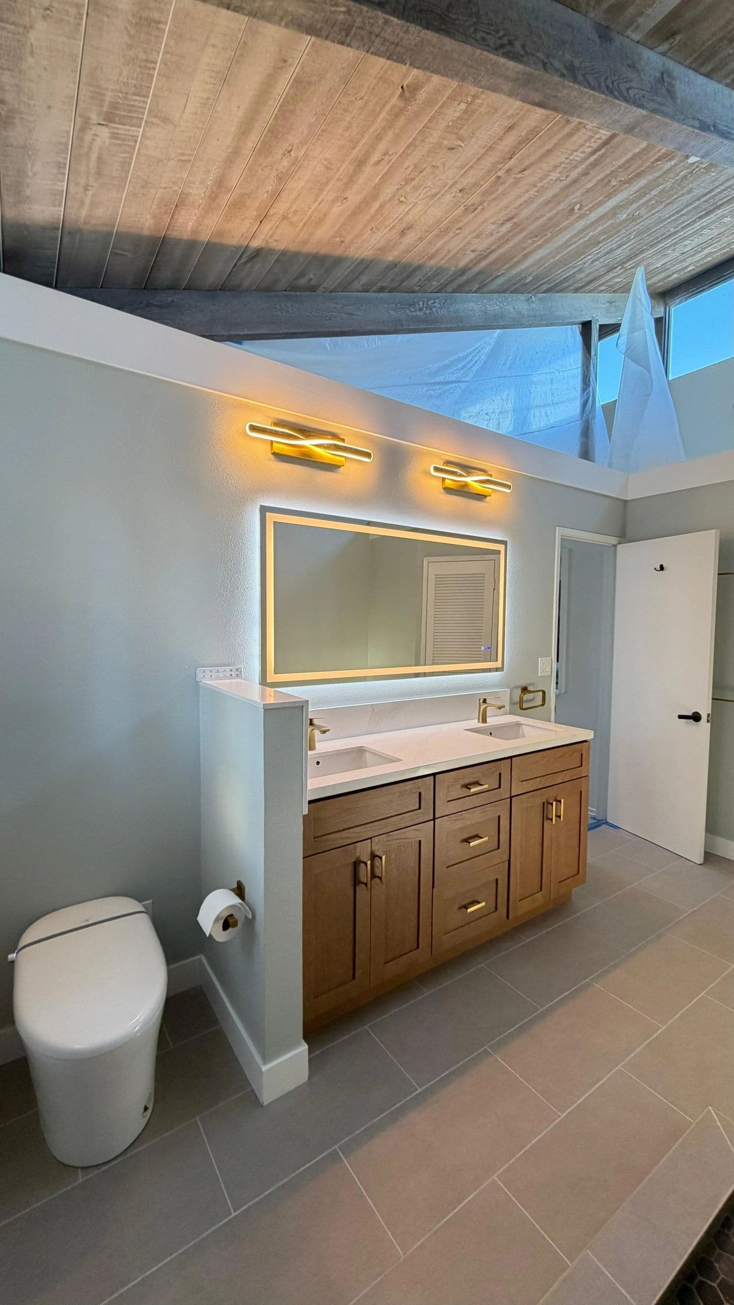 Mid-century bathroom with wood ceiling, walnut vanity and brass fixtures